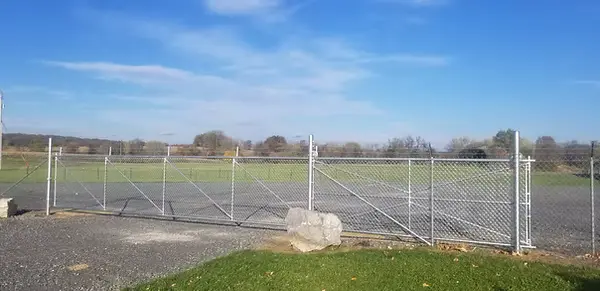 Galvanized chainlink double gates enclosing a large open property