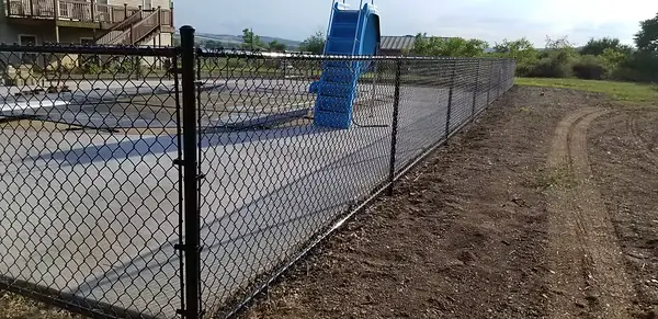 Black chainlink fence installed around a residential pool